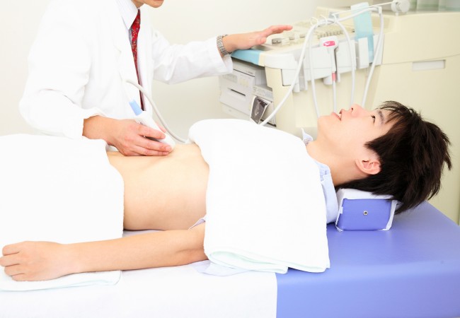 エコーで腹部を検査する男性患者